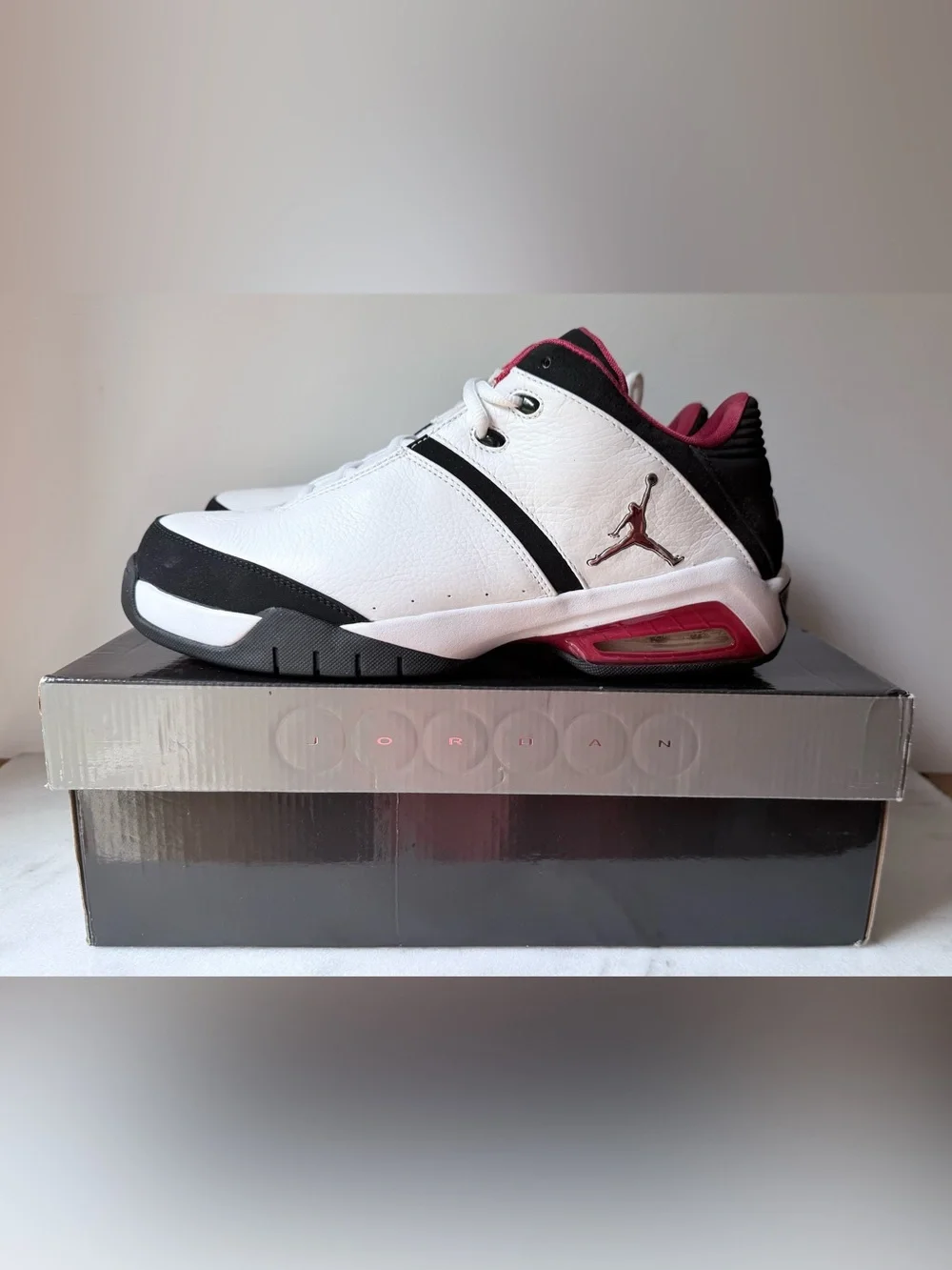Nike Jordan Team Reign Low sneakers in a white, black, and red colorway,
